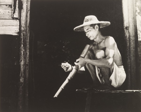 Smoking a bamboo pipe. A Chinese worker enjoys his bamboo pipe during a smoking break. Hong Kong,