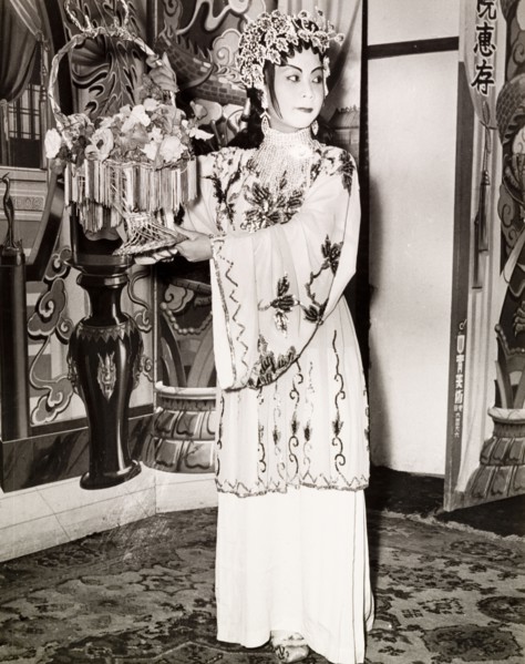 Portrait of a Chinese actress. An actress from a Chinese opera poses with a basket of flowers,