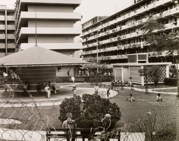 Resettlement blocks in Kowloon. Children play in a fenced park surrounded by multi-storey