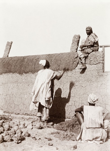 Construction of a new school in Kano. Nigerian builders put the finishing touches to a mud wall