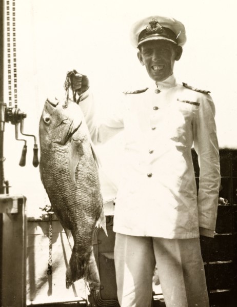 A fish caught on HMS Dauntless. The Captain of HMS Dauntless poses proudly on the ship's deck