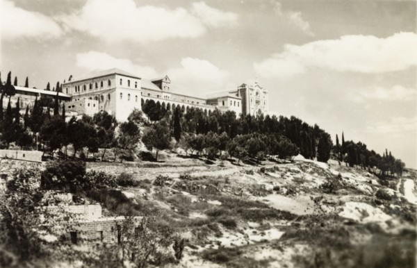 Salizian School', Nazareth. View of a large, majestic building situated atop a wooded hill,