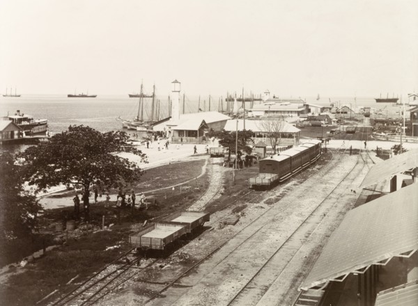 Port of Spain wharf. Empty freight cars and passenger carriages sit on sidings at Port of Spain