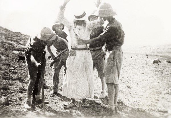 British soldiers searching a Palestinian Arab. Four British soldiers perform a body search on a