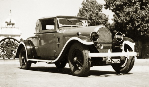 A Hotchkiss 1928, in a rich red'. A 1928 Hotchkiss car, parked outside the gates of the Victoria