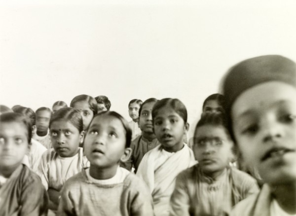 Indian schoolchildren. A class of Indian schoolchildren sit on the floor and listen attentively to