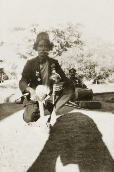 Indian snake charmer. An Indian snake charmer poses for the camera with a coiled up cobra