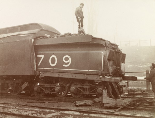 Train crash, Ontario. Railway workers inspect the damage caused to the rear of a steam locomotive
