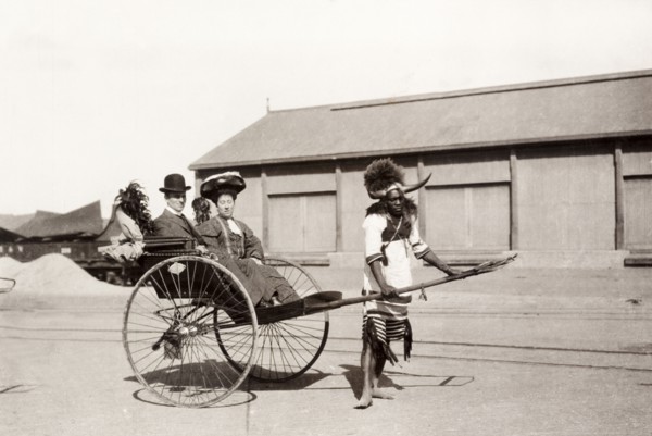 Zulu rickshaw driver, Durban. A Zulu rickshaw driver takes a European couple for a ride. He is