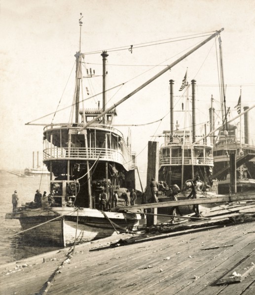 Unloading oil cake, New Orleans. Sacks of oil cake is unloaded from a cargo ship at a wharf on the