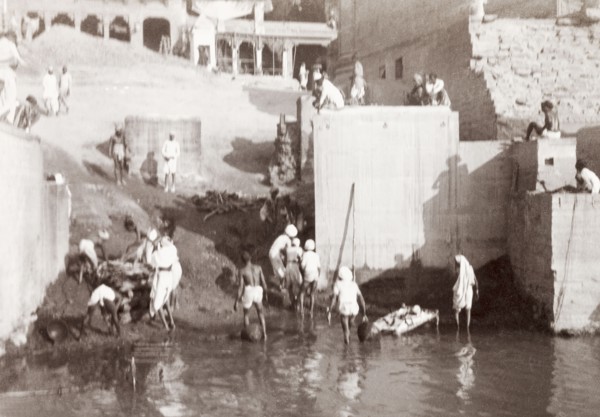 A cremation ghat in Benares. Mourning Hindus prepare to perform a cremation at a ghat (stepped