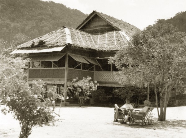 A weekend residence on Pangkor Island. Two European men relax in chairs outside a stilted bungalow