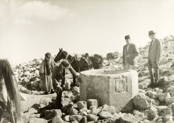 Stone well in the desert. William Ryder McGeagh, District Commissioner in Jerusalem, examines a