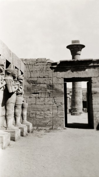 Temple of Ramesses III at Karnak. A line of eroded stone statues guard a courtyard in the Temple of