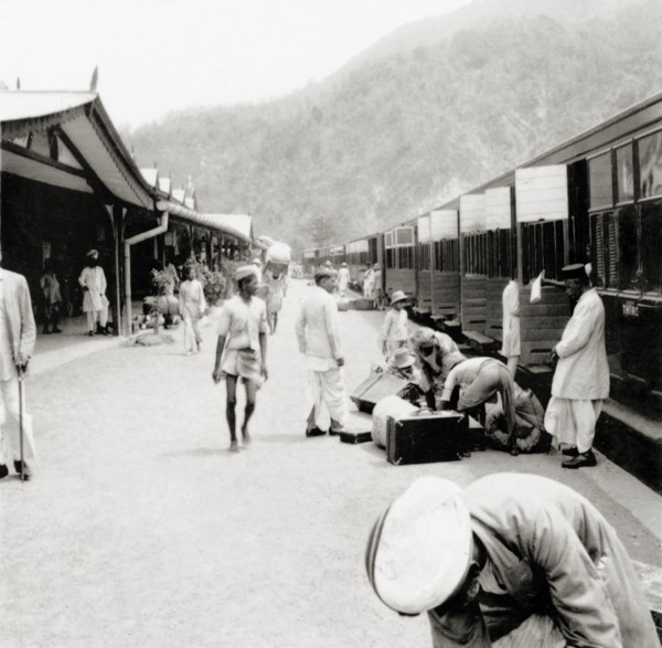 Unloading luggage at Kathgodam railway station. Indian porters help European passengers to unload