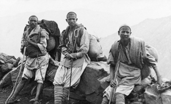 Kashmiri travellers at rest. Three of George Boon's Kashmiri porters rest their heavy loads against