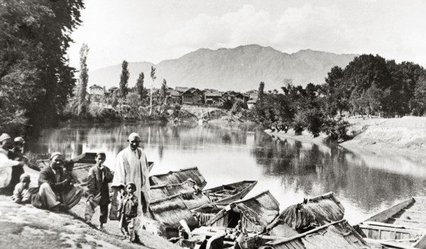 Evening on the Jhelum'. A group of men and small children mill about on a steep riverbank above the