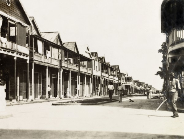 City street in Colon, Panama. Wooden, balconied buildings line the main street running through the