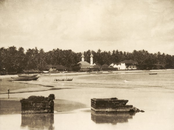 Madayi Mosque in Kannur. View across a sandy bay looking towards Madayi Mosque. The white marble