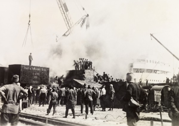 Fire at Jaffa Harbour. Smoke billows from the quayside at Jaffa Harbour as a team of men try to