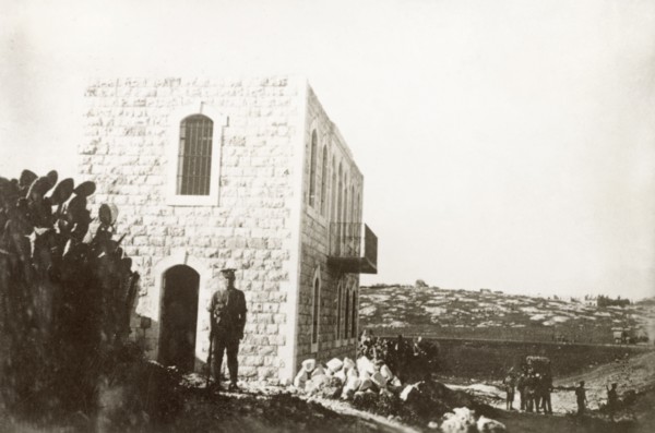 A condemned house in Nablus. A British Army officer stands on guard outside a house on the