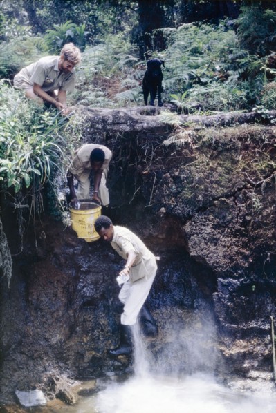 Adding lime to neutralise the water. District Forest Officer James Lang Brown (top) watches as two
