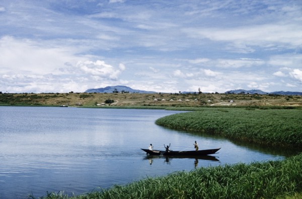 Fishermen in the Kazinga Channel'. Three men in a canoe fish with nets in The Kazinga Channel, half
