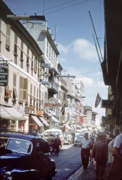 A street in Gibraltar'. View along a city street in Gibraltar, bustling with traffic, pedestrians
