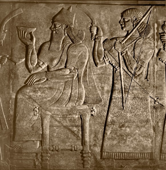 The king, Ashurnasirpal is seated between two attendants