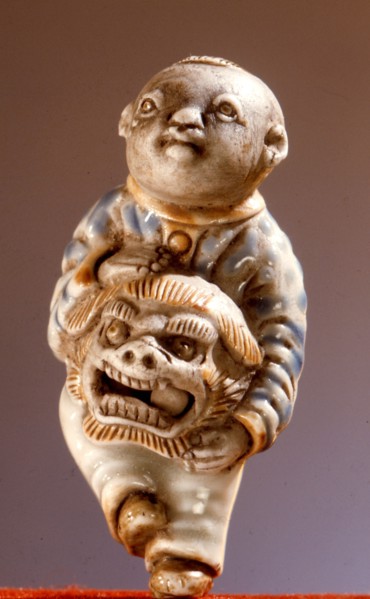 Porcelain netsuke of a lion dancer