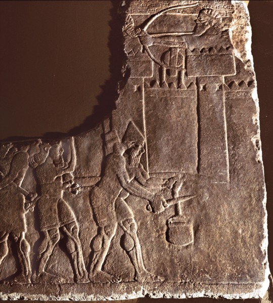 Fragment of a relief showing Assyrian soldiers cutting a well rope of a besieged city