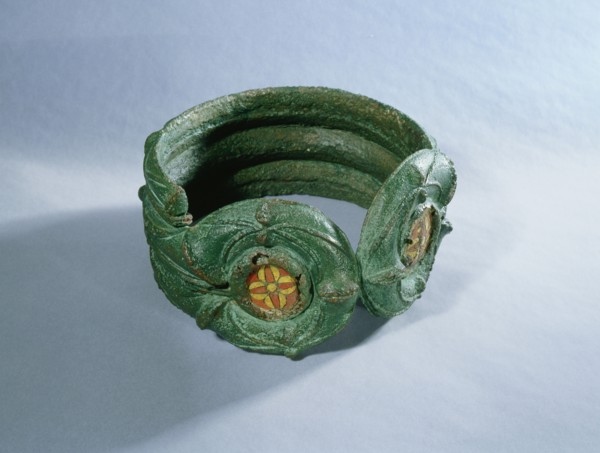 Heavy bronze bracelet decorated with enamelled discs and coloured glass