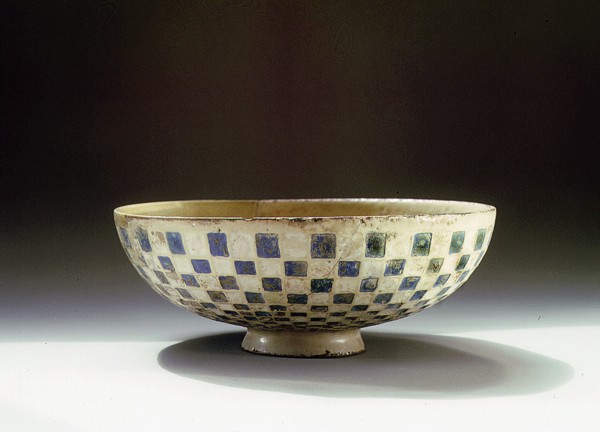 A pottery bowl with a blue and white chequer pattern on the outside