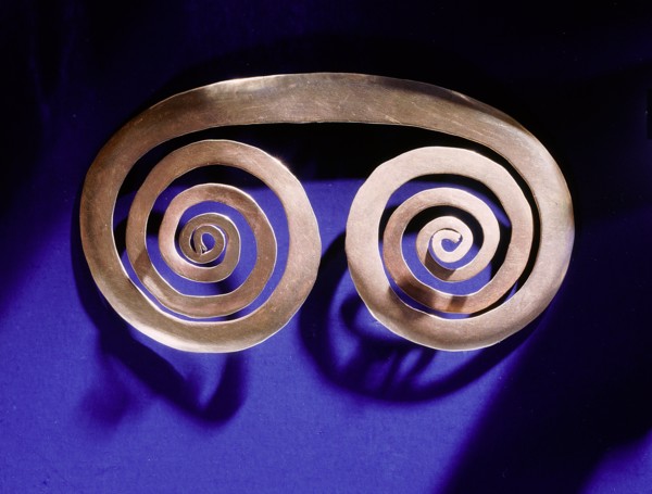 Gold spiral breast ornament thought to be a schematic representation of an owls face