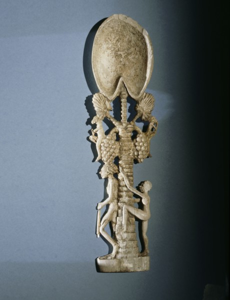 Unguent spoon in the form of a  palm tree with  a guard at  its  foot