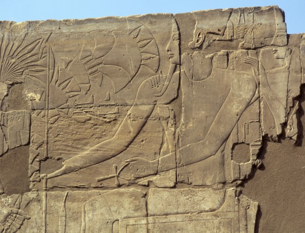 Relief from the walls behind the processional colonnade of Amenophis III depicting Tutankhamun offering flowers to a seated deity