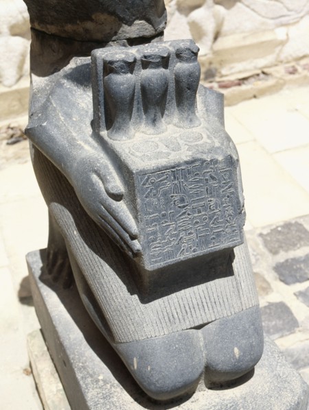 Lower portion of a kneeling sculpture of the physician Horkheb, presenting an offering table bearing hes vases