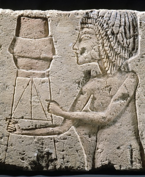 An Amarna relief showing a figure carrying an offering vessel