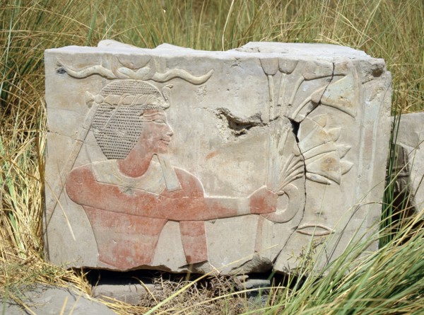Block from a painted relief depicting a king with a rams horn headdress presenting an offering of flowers