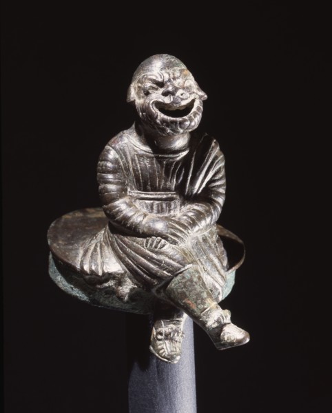 Bronze figure of a comic actor seated on a cylindrical lid, possibly from an incense burner
