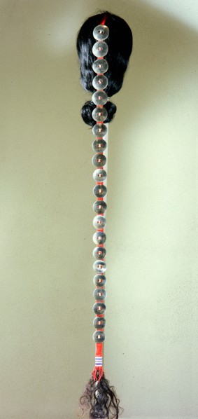 Men often wore hair plates in a graduated series strung on a leatherstrap as a hair decoration