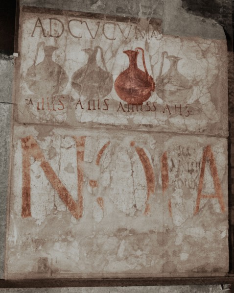 A wine shop sign in the main street, advising to come to the sign of the bowls (ad cucumas)