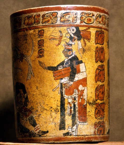 Cylindrical vessel decorated with date glyphs and a Mayan ball player wearing black body paint and heavy padding for the competition