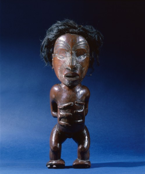 Carved wooden human figure with inlaid metal eyes and human hair