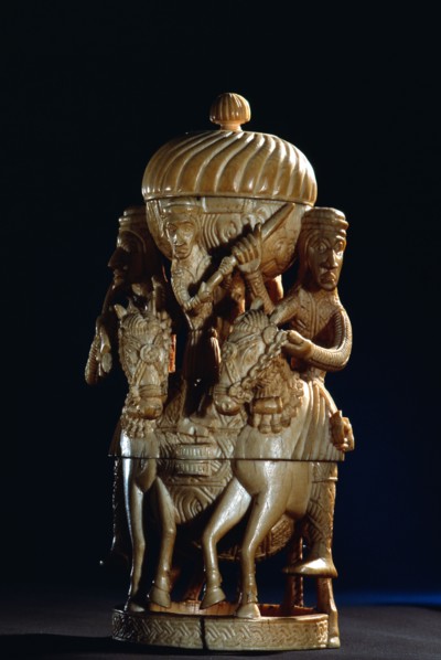 An ivory salt cellar around the base of which are figures of Portuguese noblemen