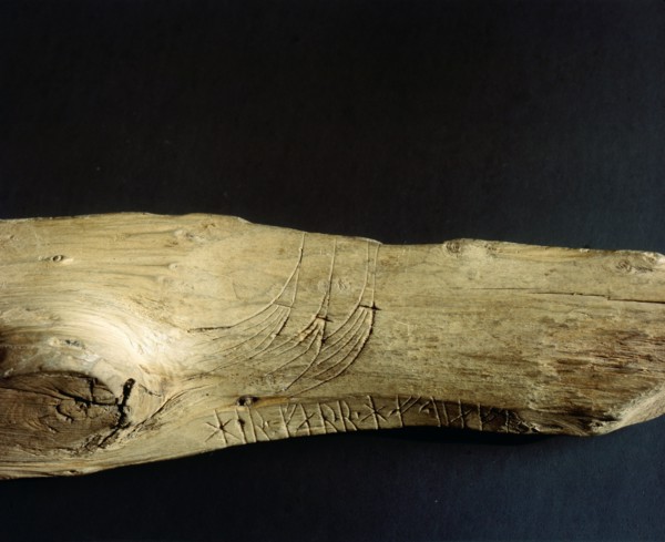 Three Viking ship prows incised on a piece of wood