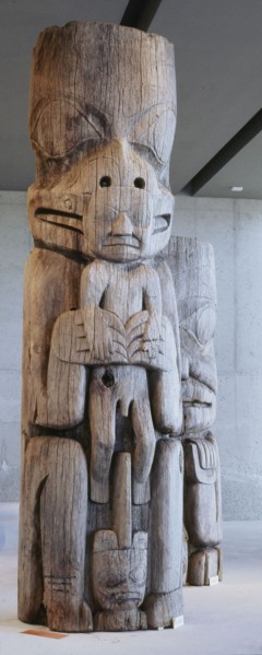 Section of a house frontal pole showing a bear holding a man