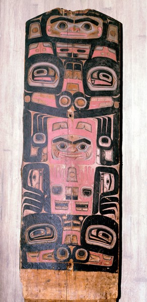 A carved and painted cedar board with a design showing ancestry and social position