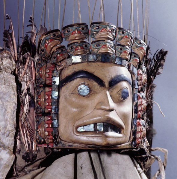 Chiefs headdress with humanoid face surrounded by a row of abalone shell and a double row of smaller faces