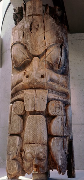 Frontal house post carved with a beaver which can be identified by its prominent teeth and scaly cross hatched tail